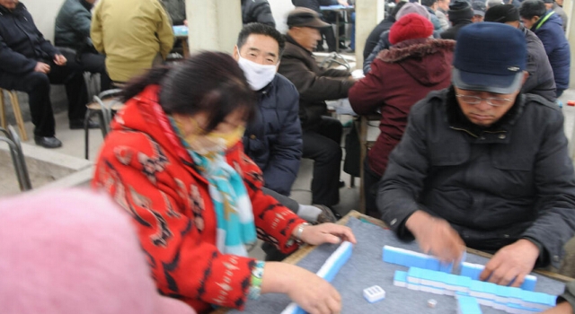 真爱!济南大爷大妈不惧雾霾 街头露天搓麻将