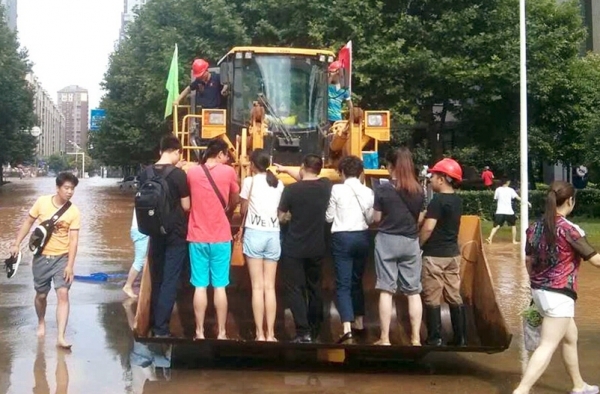 霸气!积水严重武汉市民乘铲车上班 1次10元供不应求