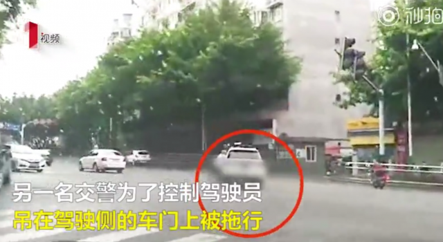 无法无天！女子驾车一路狂飙 交警挂车身上被拖行数百米
