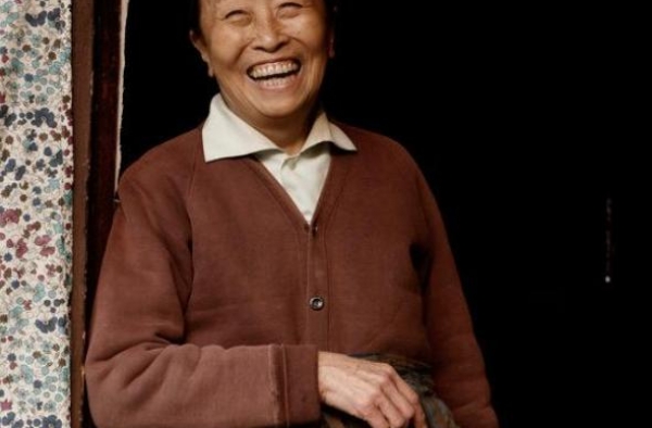 “丑娘”张少华家中全貌，破损墙壁泛黄简陋，与桌上奖杯形成对比