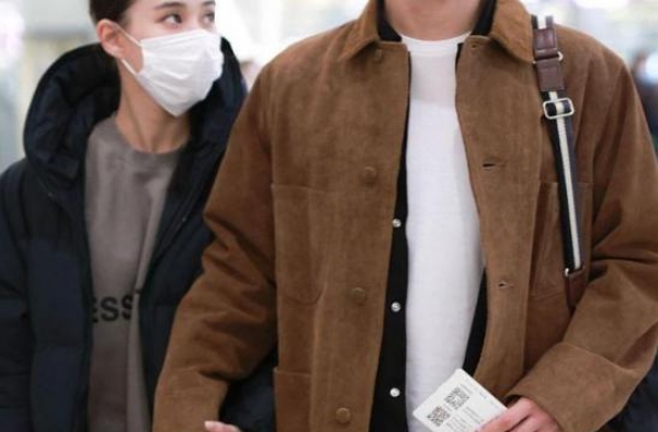 何超莲与男友甜蜜走机场，两人造型格外休闲，十指相扣太甜蜜